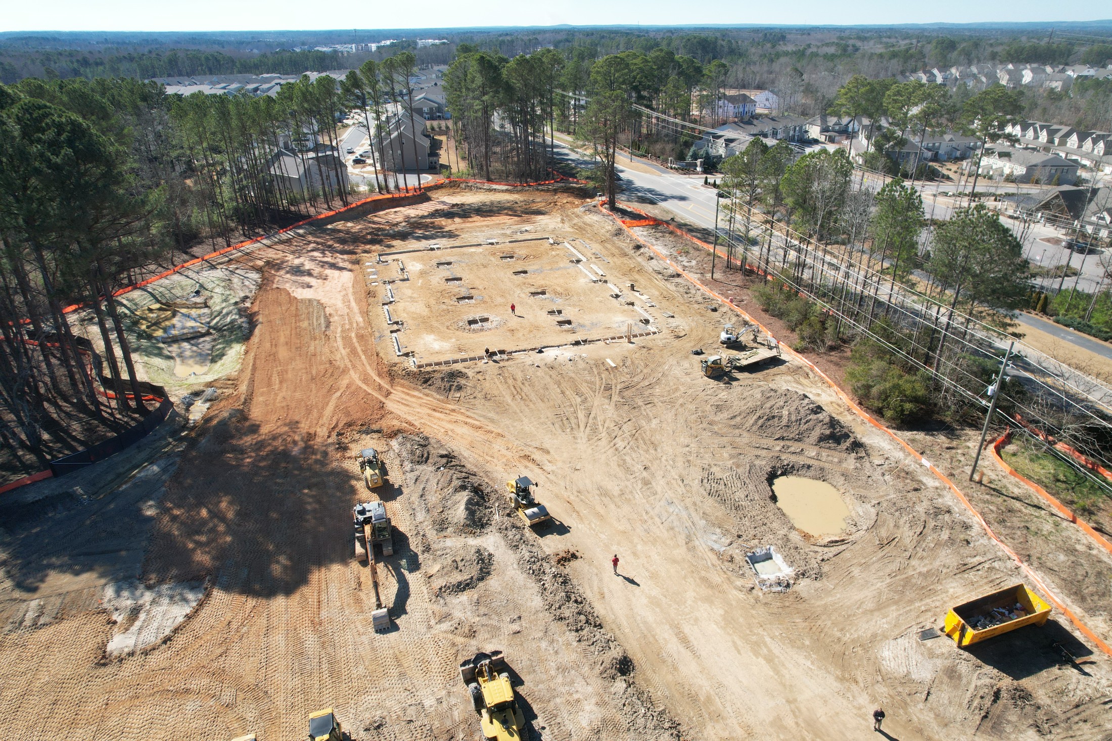 Construction grid aerial showing cleared land, access routes, and staging areas